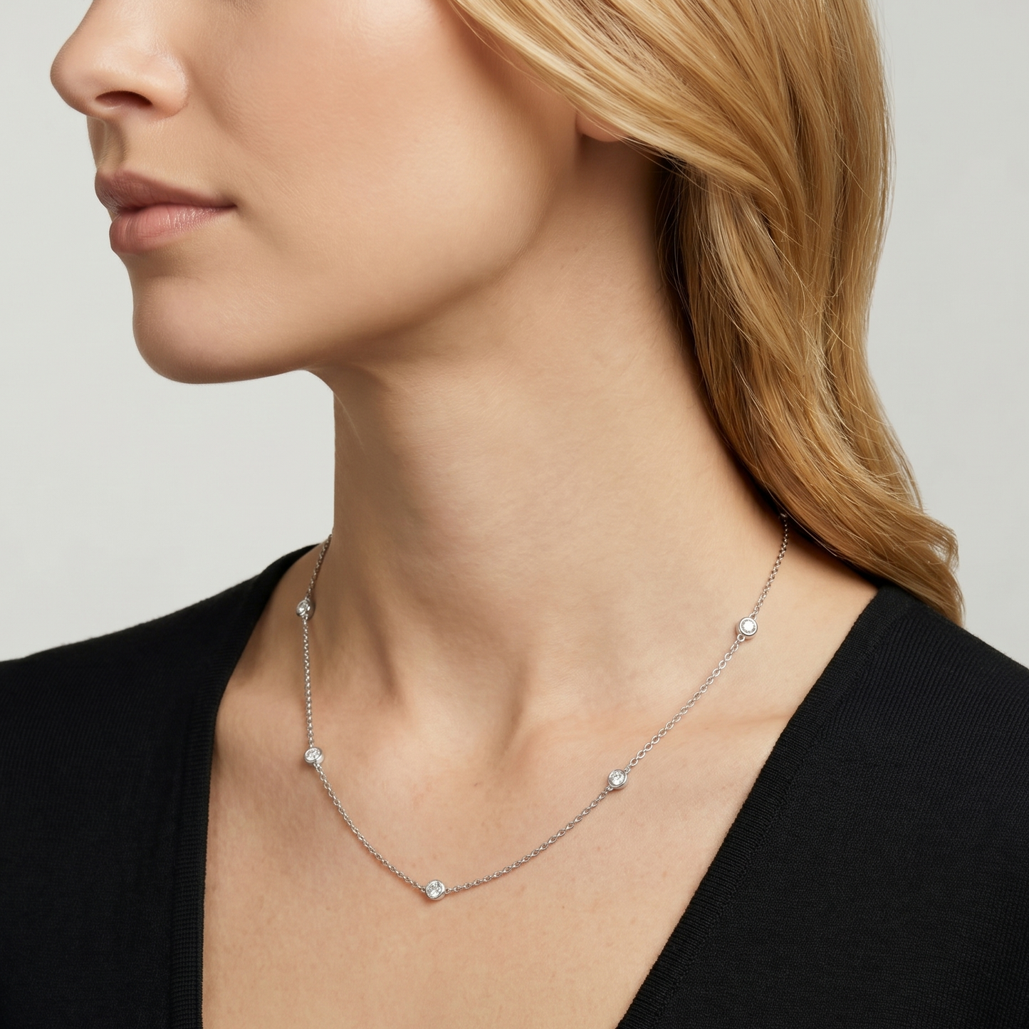 white gold diamond station necklace worn on woman